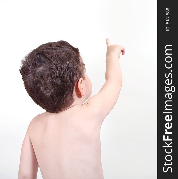 3 year old boy facing wall and pointing up. 3 year old boy facing wall and pointing up