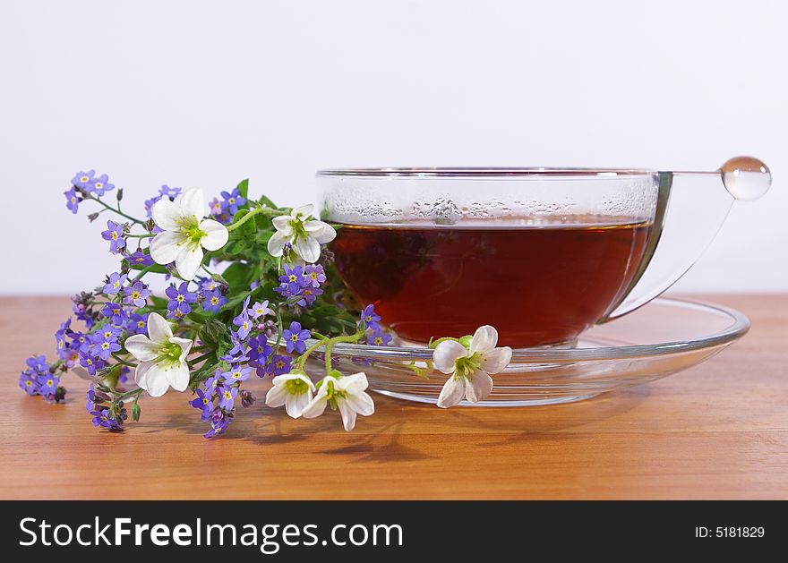 Tea in a transparent cup and flowers. Tea in a transparent cup and flowers
