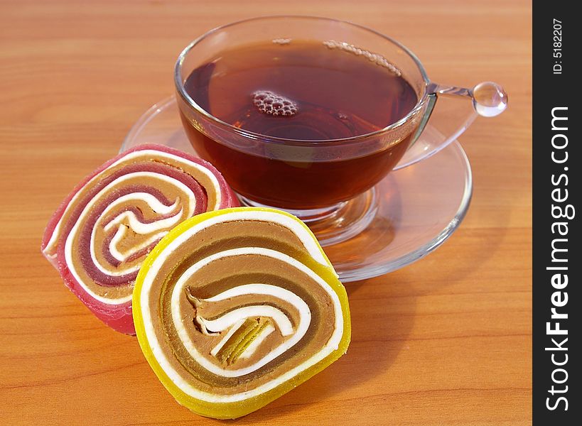 Multi-coloured fruit candy and cup of tea. Multi-coloured fruit candy and cup of tea