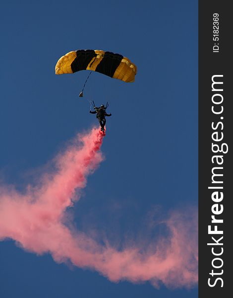Skydiver in mid-air with colored smoke flowing behind him. Skydiver in mid-air with colored smoke flowing behind him.