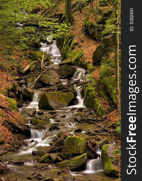 Mountain river in the forest of mountains with a waterfall