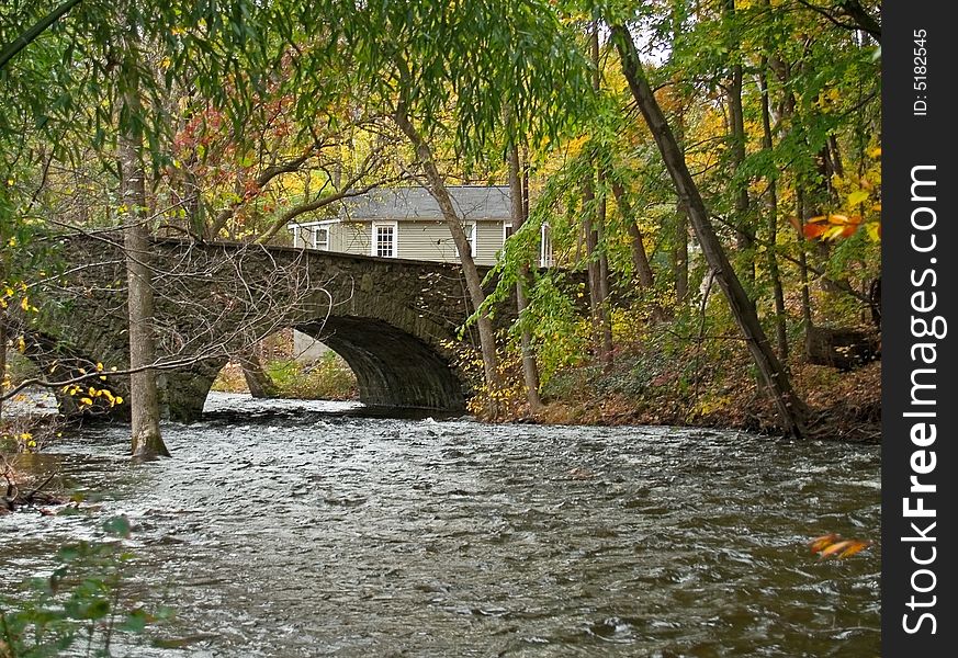 An old stone bridge over a wooded stream in the scenic Pocono Mountains of Pennsylvania.