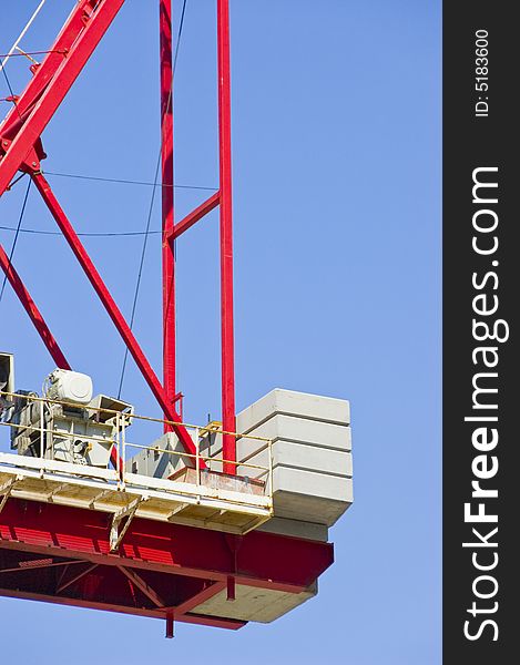 Construction crane busy at work on a sunny day with blue sky