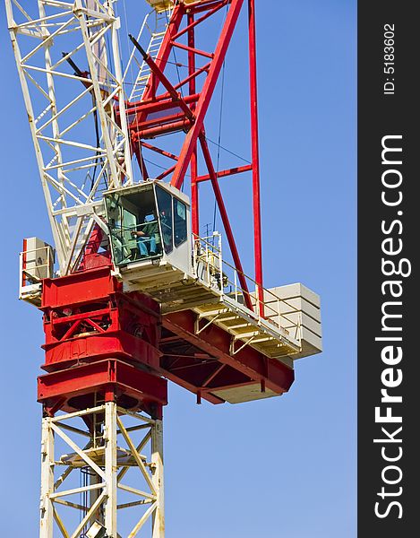 Construction crane busy at work on a sunny day with blue sky