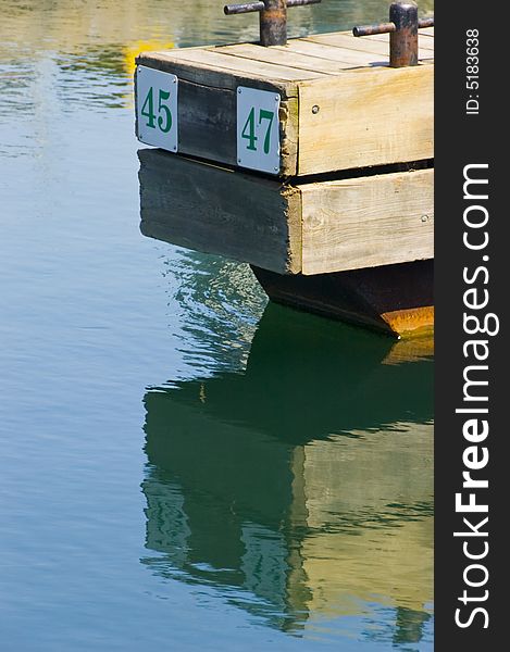 A reflection of a dock in the water at a marina. A reflection of a dock in the water at a marina