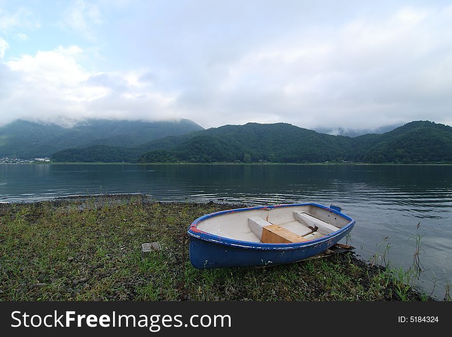 Summer morning landscape with blue boat on the lake's shore, Lake Kawaguchi, Japan. Summer morning landscape with blue boat on the lake's shore, Lake Kawaguchi, Japan