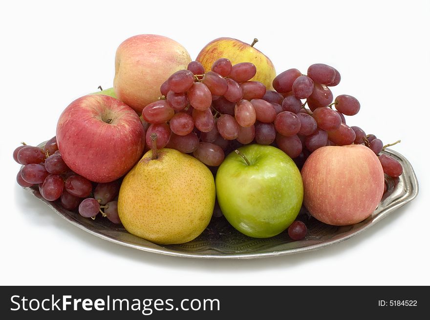 Fresh fruit on the large plate on a white background. Fresh fruit on the large plate on a white background.