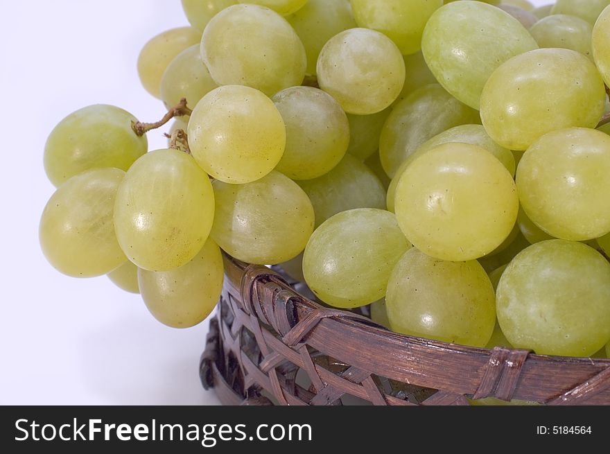 Green grapes in basket on a white background. Green grapes in basket on a white background.