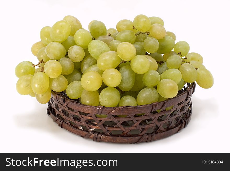 Green grapes in basket on a white background. Green grapes in basket on a white background.