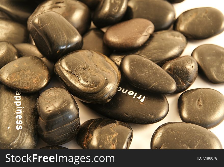 Black pebbles on a white background (shallow DOF)