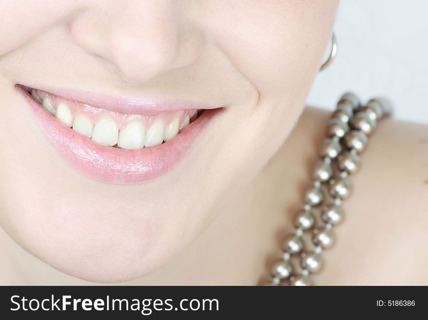 Close up of lips and teeth of a smiling woman with a necklace. Close up of lips and teeth of a smiling woman with a necklace