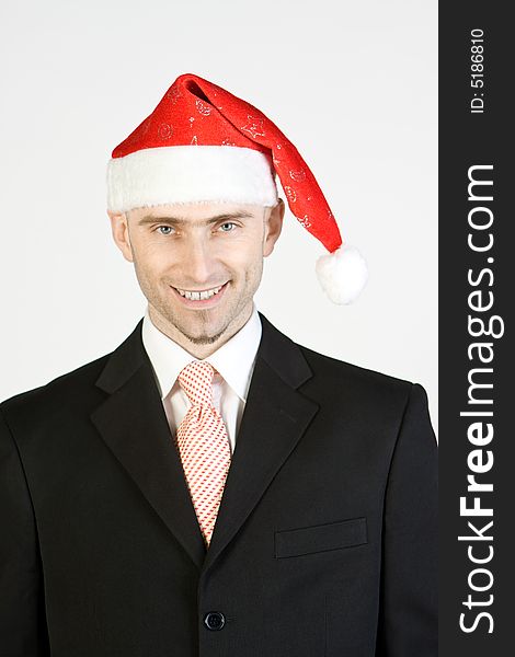 A smiling businessman wearing Santa Claus hat, white background. A smiling businessman wearing Santa Claus hat, white background.