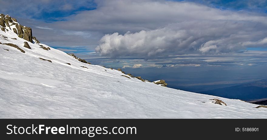 Snowy white mountain slope with blue sky panorama. Snowy white mountain slope with blue sky panorama