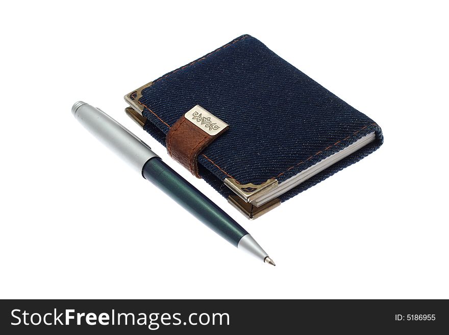 The closed notebook and ball pen on a white background