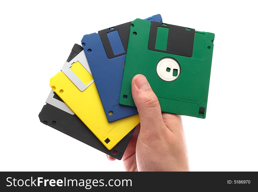 The hand holds some multi-coloured diskettes on a white background