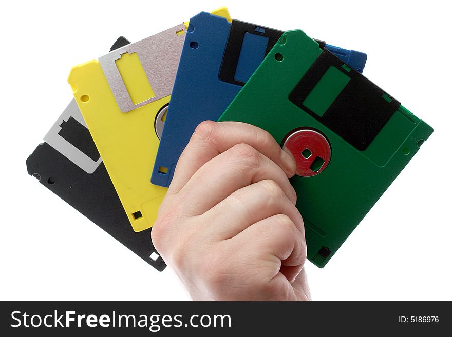 The hand holds some multi-coloured diskettes on a white background