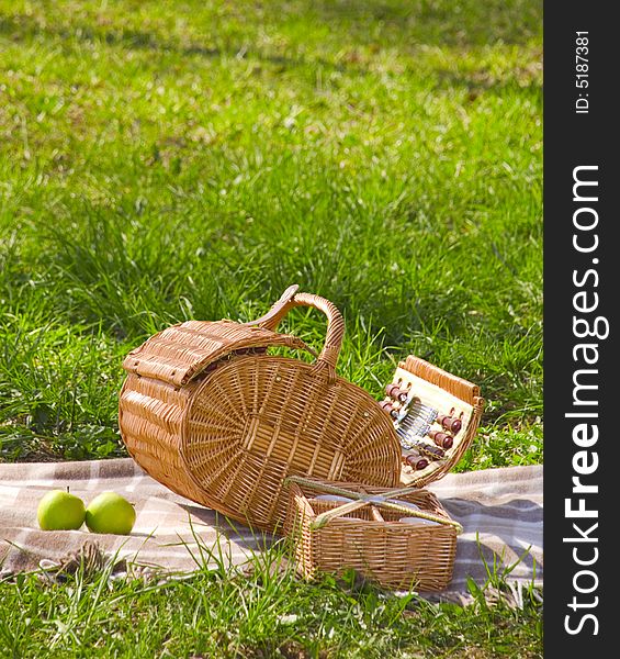 Basket for the picnic with two apples on the plaid. Basket for the picnic with two apples on the plaid