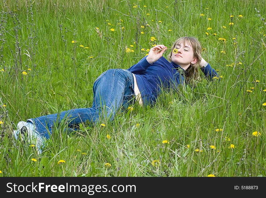 Girl lays on a grass and smells dandelion. Girl lays on a grass and smells dandelion