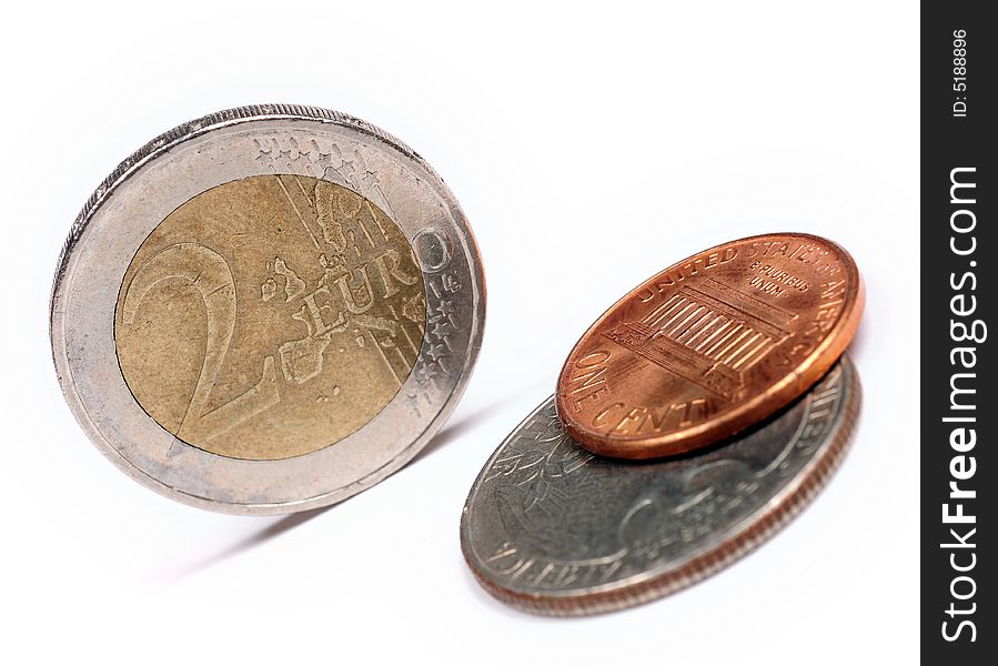 A close up with euro coins against dollars over a white background. A close up with euro coins against dollars over a white background