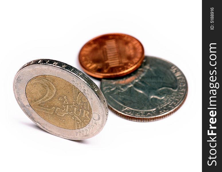 A close up with euro coins against dollars over a white background. A close up with euro coins against dollars over a white background