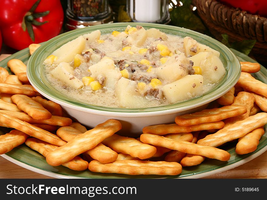 Bowl of beef chowder in bowl with crackers.