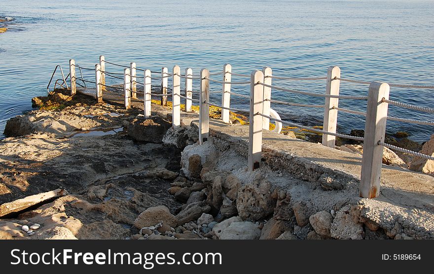 View of a pier at a rocky beach at paphos area in Cyprus. View of a pier at a rocky beach at paphos area in Cyprus