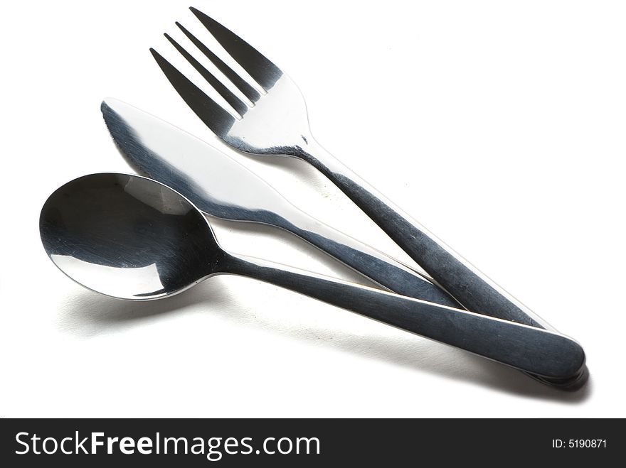 Spoon, knife and fork on the white background with shadow. Spoon, knife and fork on the white background with shadow.