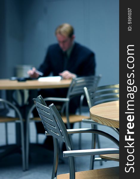 Businessman wearing suit sitting down at table crunching the numbers. Businessman wearing suit sitting down at table crunching the numbers