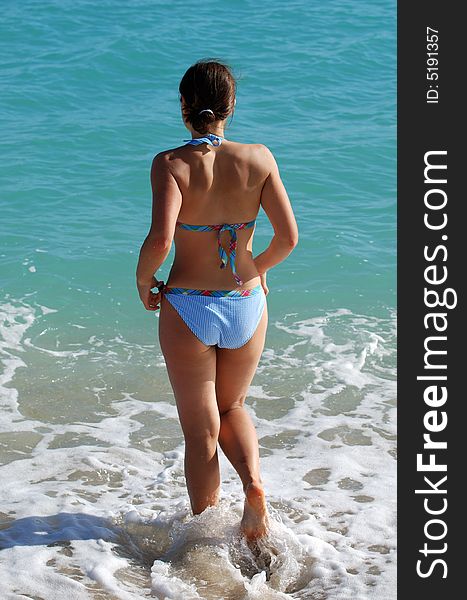 The girl running to swim on Philipsburg beach, St.Maarten island. The girl running to swim on Philipsburg beach, St.Maarten island.