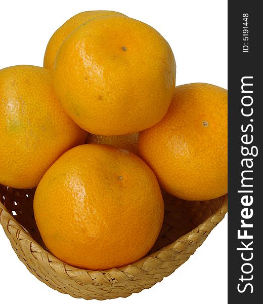 The large ripe juicy oranges with a yellow leather(skin) lay in a straw plate. The large ripe juicy oranges with a yellow leather(skin) lay in a straw plate