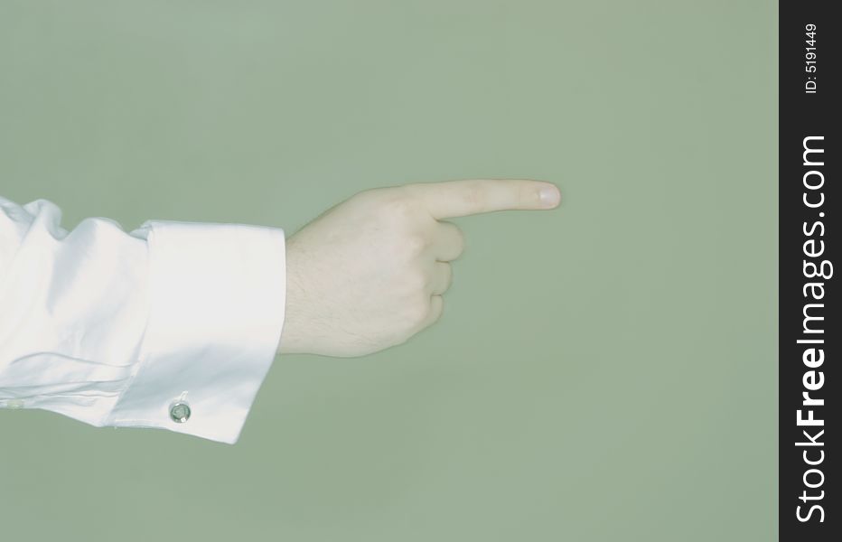 Single arm and hand with one finger pointing against green background. Single arm and hand with one finger pointing against green background