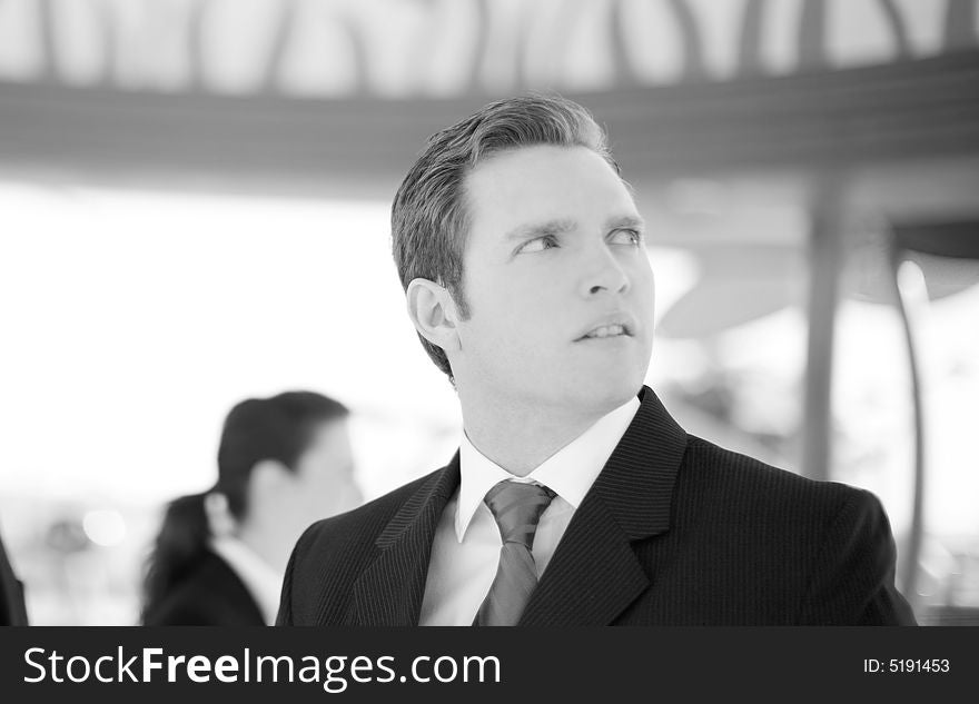 Business people standing wearing suits with one businessman looking away with worried look