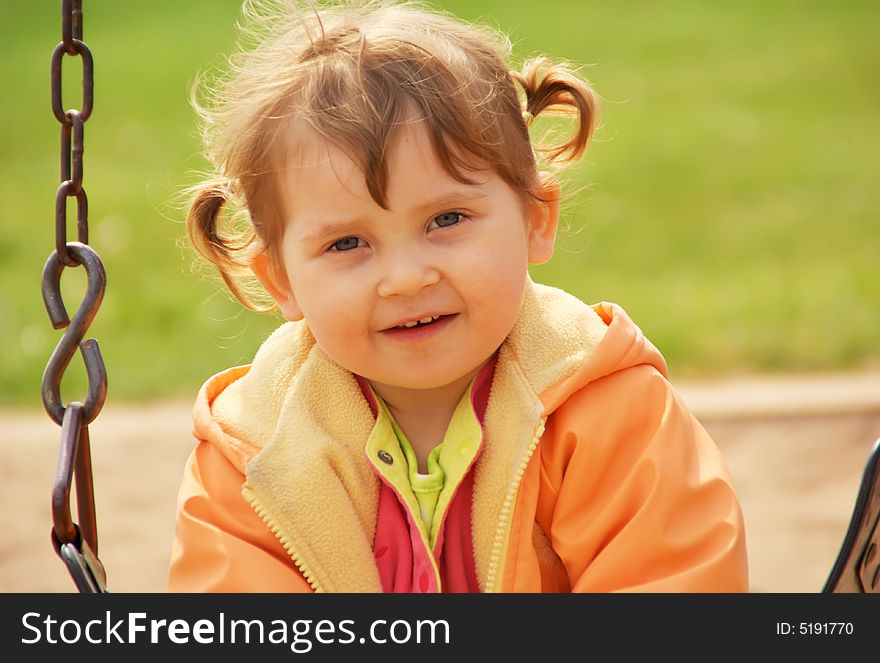 Little girl at park playground. Green grass  background. Spring time. Little girl at park playground. Green grass  background. Spring time.