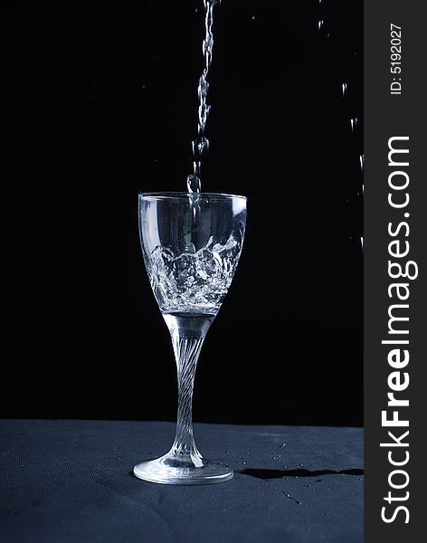 Water splashing in glass at black background. Water splashing in glass at black background