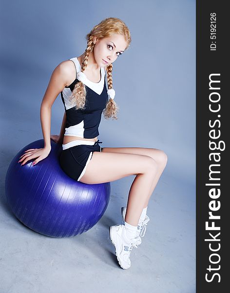 Woman go in for fitness with big blue ball. Woman go in for fitness with big blue ball