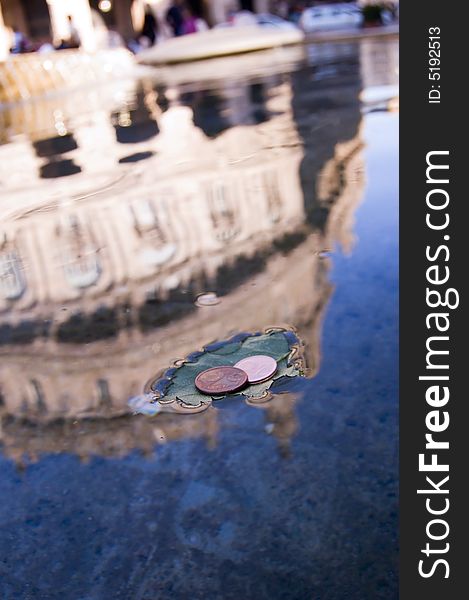 Coins on a leaf in a fountain in Piazza De Ferrari,  Genoa, italy. Coins on a leaf in a fountain in Piazza De Ferrari,  Genoa, italy