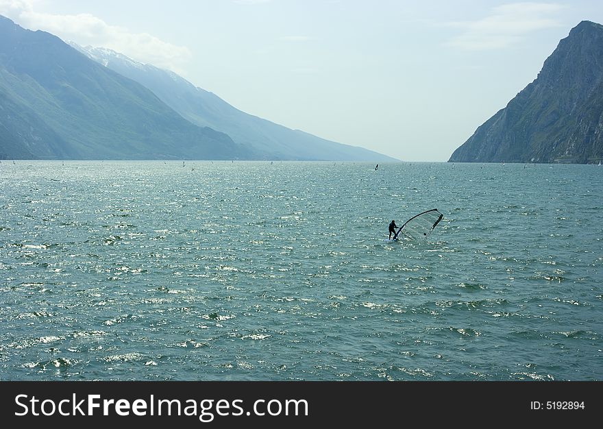 Surfer practicing sports activity on Garda lake. Surfer practicing sports activity on Garda lake