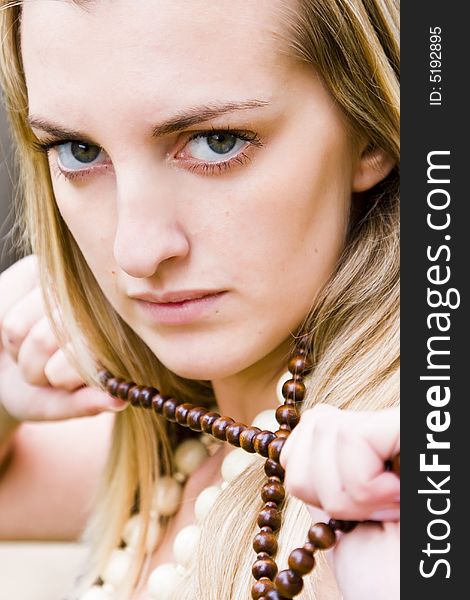 Young blond woman holding a necklace. Young blond woman holding a necklace.