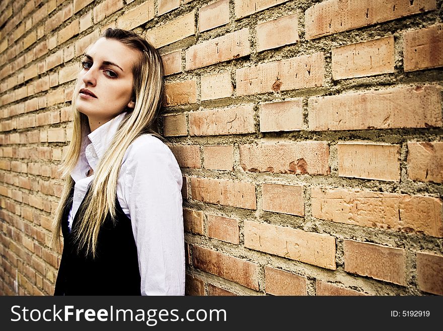 Blond woman on wall staring at camera