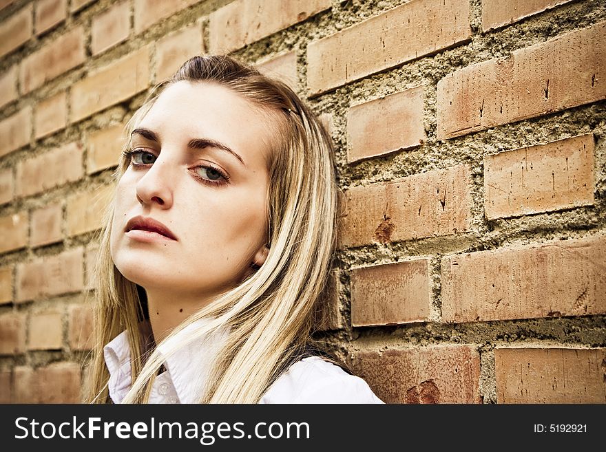 Blond woman on wall staring at camera