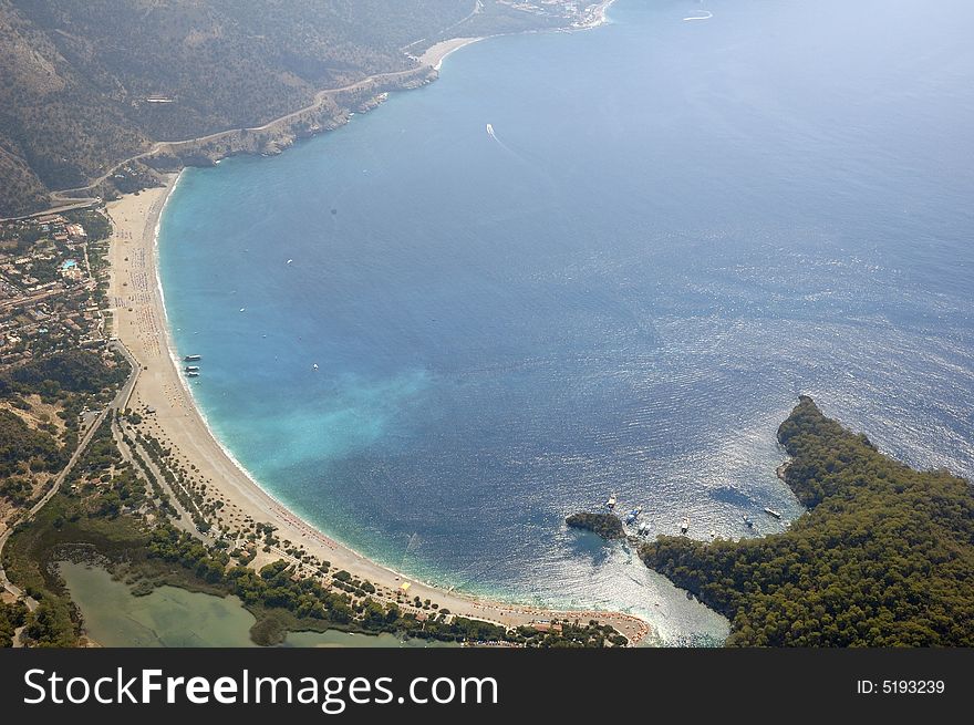 Aerial view on blue bay, coastal beach and road