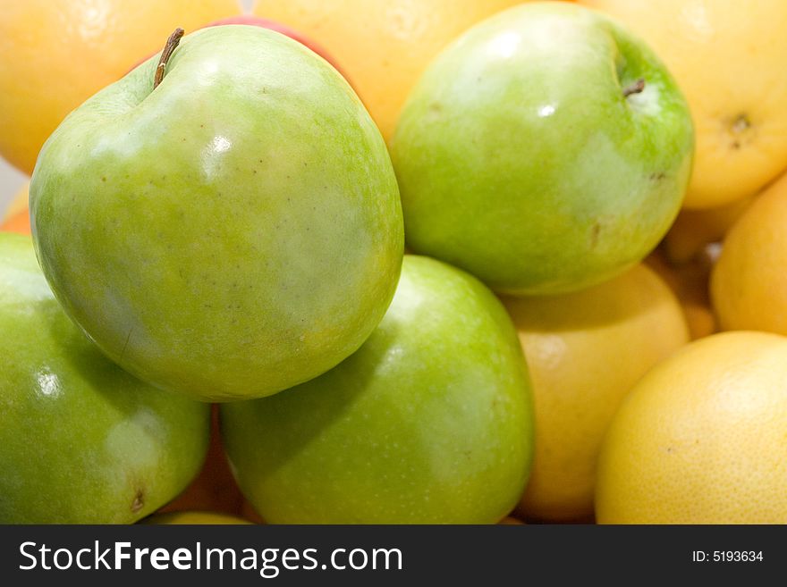 A bunch of citric fruits and some apples. A bunch of citric fruits and some apples