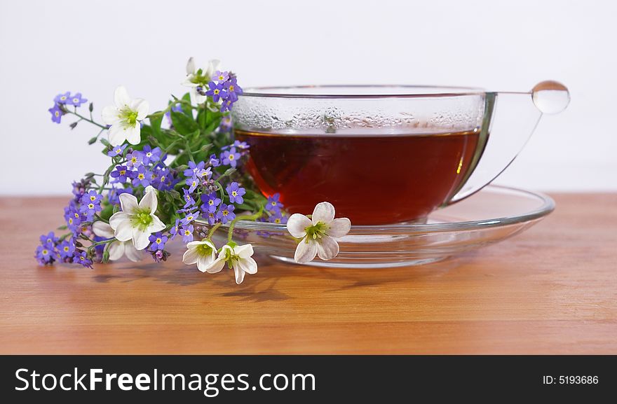 Tea in a transparent cup and flowers. Tea in a transparent cup and flowers