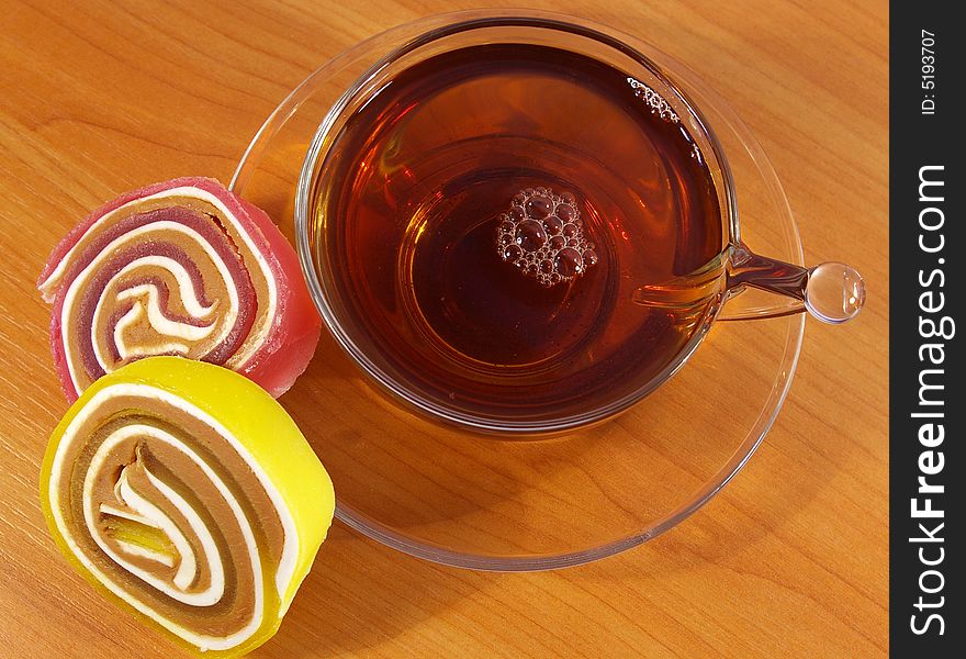 Colorful fruit candy and black tea