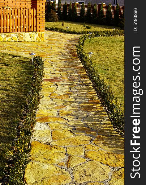 Garden stone path with grass growing up between the stones. Garden stone path with grass growing up between the stones