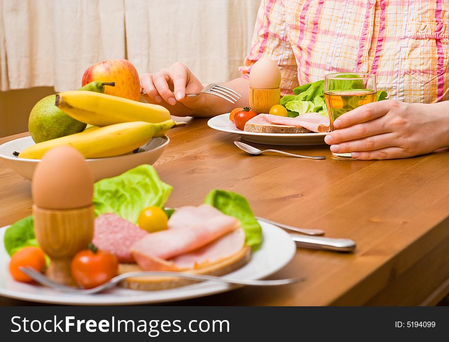 Woman eating snacks. Fruits, vegetables, bread, egg, ham etc. Focus on the person. Woman eating snacks. Fruits, vegetables, bread, egg, ham etc. Focus on the person.