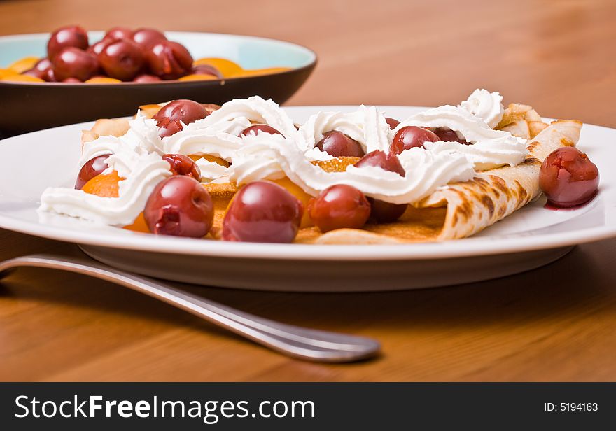 Pancakes served with fruits and whipped cream. Pancakes served with fruits and whipped cream.