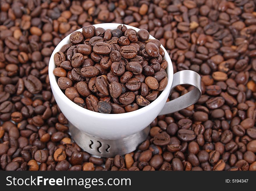 Cup of coffee beans on coffee beans background