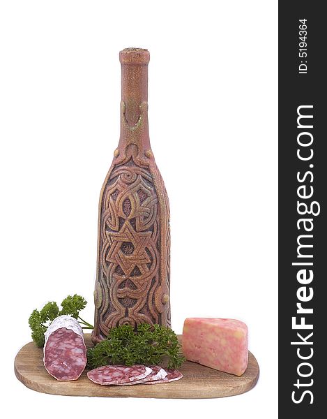 Still-life on a wooden hardboard with parsley, sausage, cheese and bottle isolated on white.