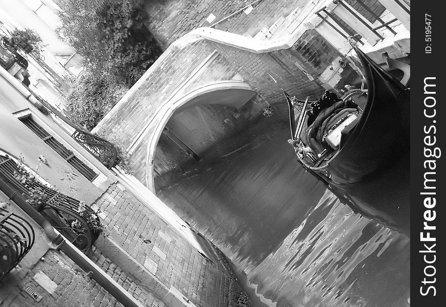 Venice (Italy) postcard: a quiet canal corner in Venice with gondola, brick bridge and palace facade with flowers;  black and white image. Venice (Italy) postcard: a quiet canal corner in Venice with gondola, brick bridge and palace facade with flowers;  black and white image